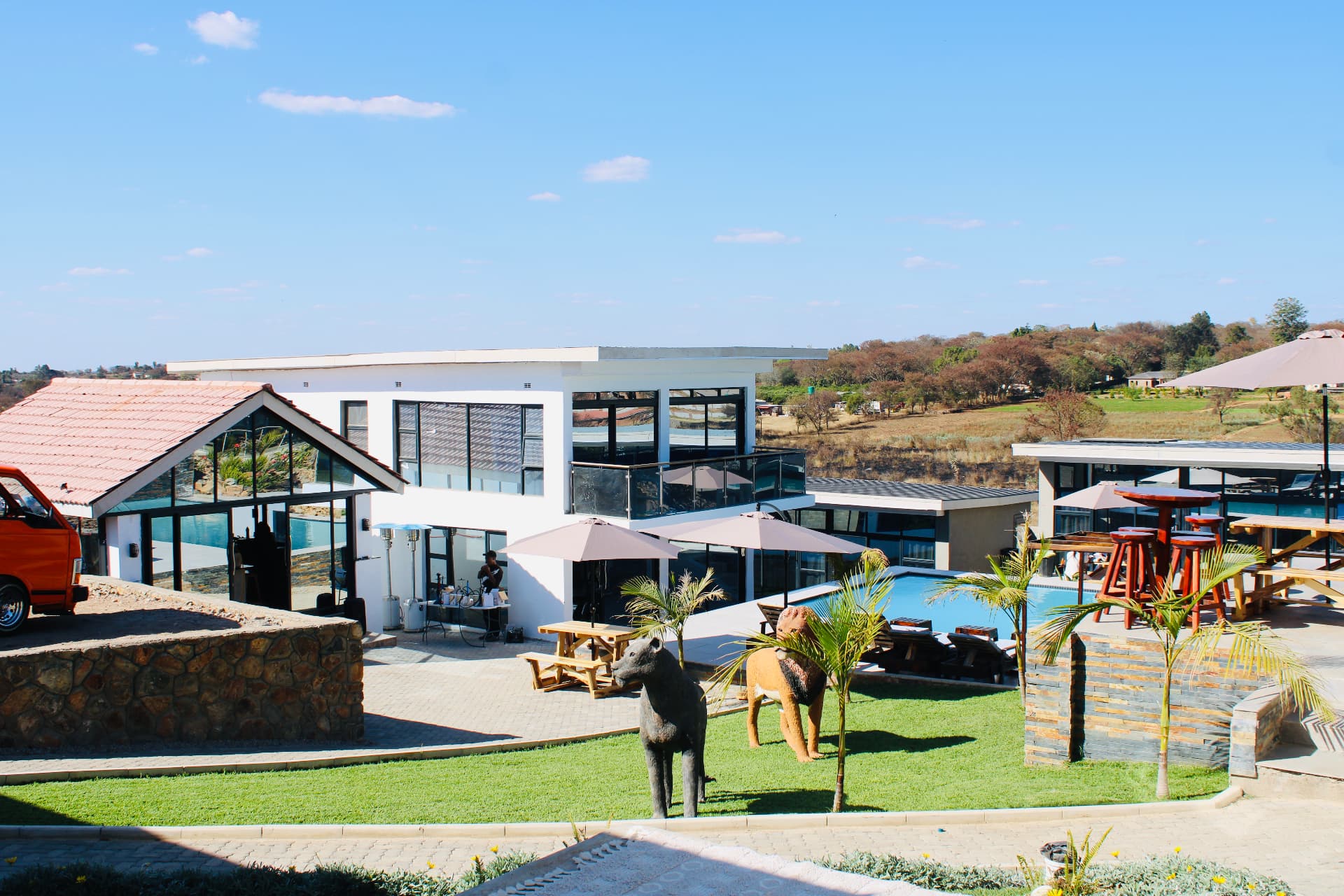A wide view of Lions Gate with the pool, terrace bar and lion sculptures